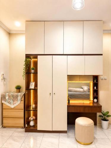 a bedroom with a bed with white cabinets at Lamar home in Jakarta