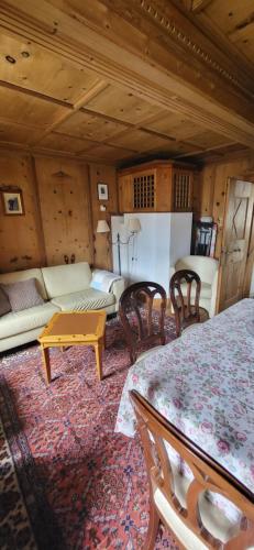 a living room with a couch and a table and chairs at Casa Silvia in Promontogno