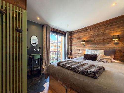 a bedroom with a bed with a wooden wall at Homency - Résidence Ménandière V2 spot in L'Alpe-d'Huez