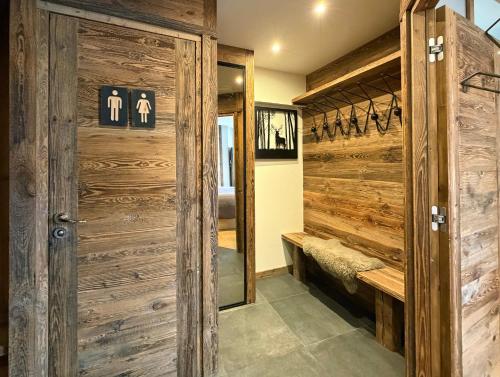 a bathroom with a wooden door and a mirror at Homency - Résidence Ménandière V2 spot in L'Alpe-d'Huez