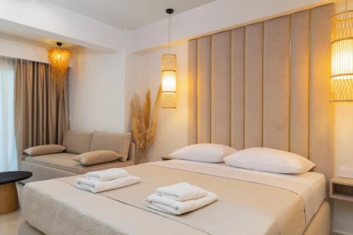 two beds in a room with towels on them at MaDaM Essence in Nei Poroi