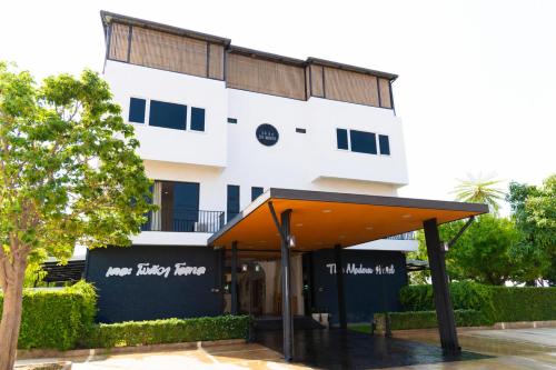 a white building with an awning in front of it at The Modeva Hotel in Kanchanaburi City