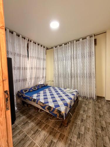 a bedroom with a bed and a window with curtains at Luxury Mountain Chalet with Private Pool Lionden Jerash in Jerash