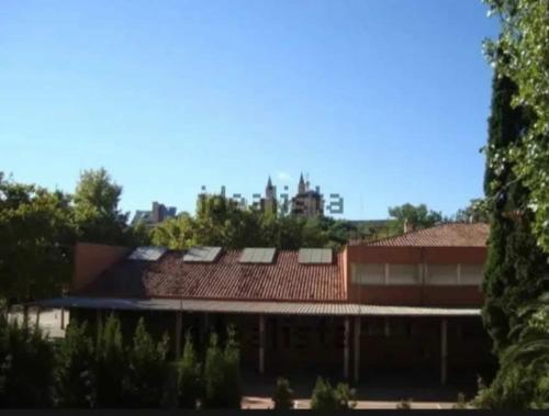 a building with red roofs and trees in the background at Casa Lago in Zaragoza