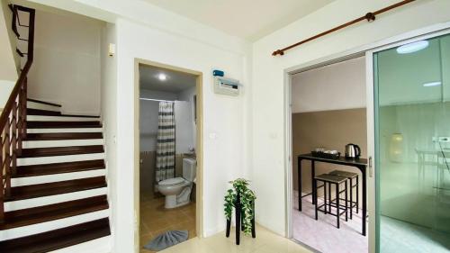 a bathroom with a staircase and a toilet in a room at City Hill Residence in Ban Khok Chang