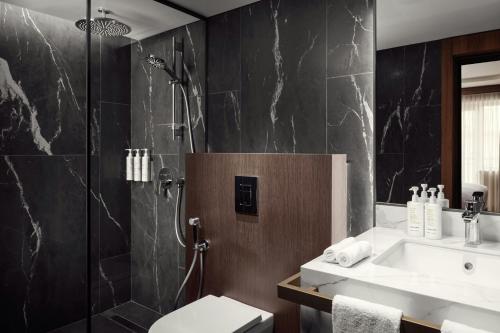 a bathroom with a shower and a sink and a toilet at Armenia Marriott Hotel Yerevan in Yerevan