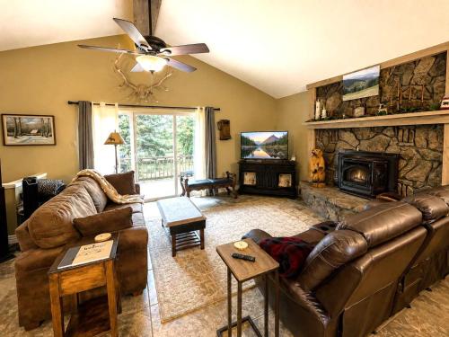 a living room with a leather couch and a fireplace at Chalet Rouge in Ruidoso