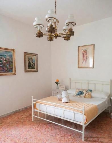 a bed in a bedroom with a chandelier at Simohouse Lecce - Executive Suite Apartment 140mq - 2 Bathrooms in Lecce