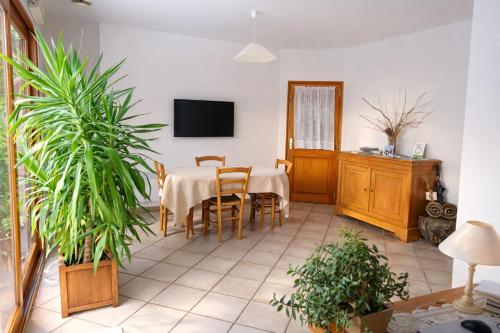 a dining room with a table and some plants at De Cian in Saint-Valéry-sur-Somme