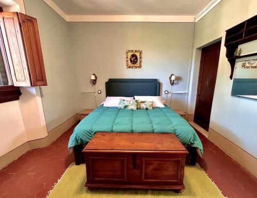 a bedroom with a bed with a green comforter at Villa Pasqui 1914 e Limonaia in Città di Castello