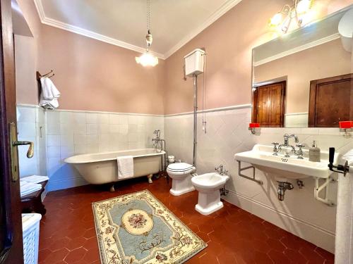 a bathroom with a tub and a toilet and a sink at Villa Pasqui 1914 e Limonaia in Città di Castello