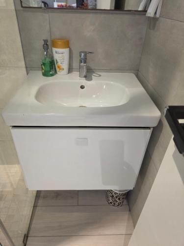 a white sink in a small bathroom at Mon jardin secret in La Marsa
