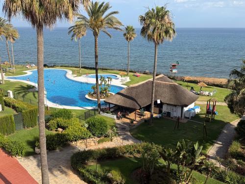 an aerial view of a resort with a pool and palm trees at MI CAPRICHO, Beach Front Apartment P14 3ºB in Mijas Costa