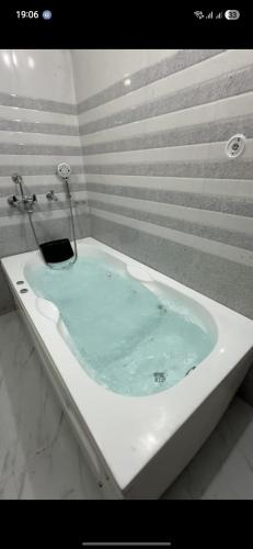 a bath tub filled with blue water in a bathroom at Veer Guest House in Bareilly