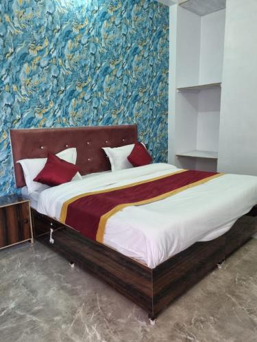 a bedroom with a large bed with a painting on the wall at Veer Guest House in Bareilly