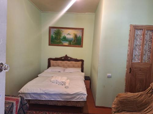 a small bedroom with a bed with white sheets at Davti Toon Guesthouse in Aghitu