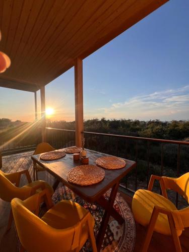 a balcony with a table and chairs and the sunset at Marjan bay in Tossor