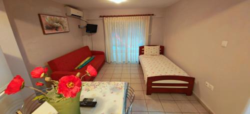 a small living room with a couch and a bed at Argiro studios in Flogita