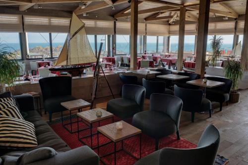 a restaurant with a piano and tables and chairs at Résidence Premium Le Bénétin- Saint Malo in Saint Malo