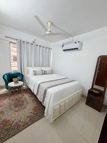 a white bedroom with a large bed and a window at Havene 11 in Dhaka