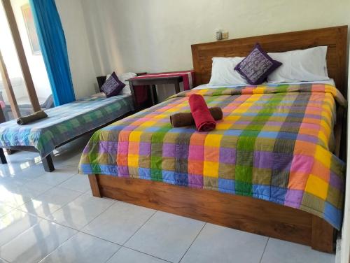 a bedroom with a bed with a colorful comforter at Kabera House 1 in Ubud