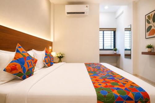 a bedroom with a large bed with colorful pillows at Hotel Evanka Brilliant Convention in Indore