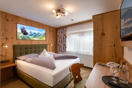 a bedroom with a bed and a desk with a computer at Hotel Garberwirt in Hippach