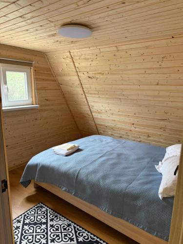 a bedroom with a bed in a wooden room at UYA A-farme in Saty