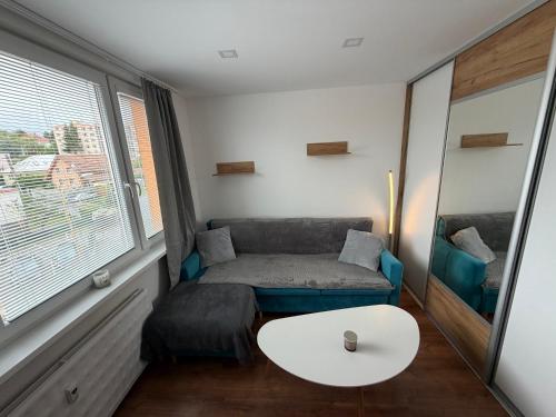 a small living room with a couch and a table at Modern stylish apartment in Prievidza