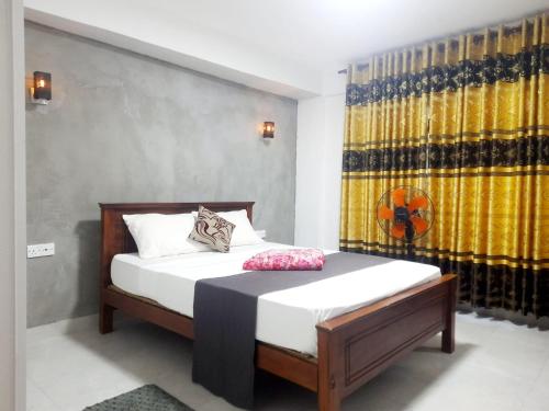 a bedroom with a bed with white sheets at Green Villa Ella in Ella