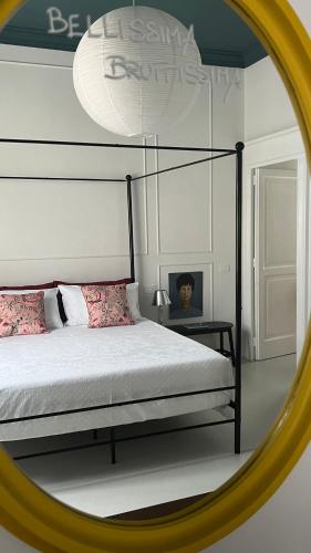 a mirror reflecting a bedroom with a bed and a bed frame at Casa Margo in Campobasso