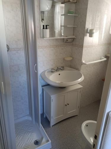 a white bathroom with a sink and a shower at Casa vacanze nel Parco della Majella in Montenerodomo
