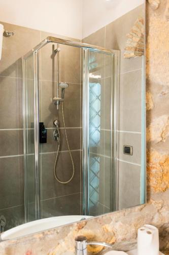 a shower with a glass door in a bathroom at Il Butto - Loft Etrusco in Tarquinia