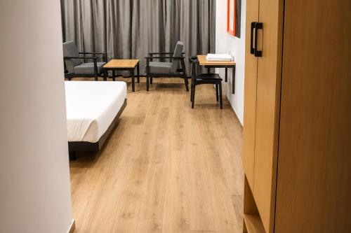 a room with a bed and a table and chairs at Hotel Somani Wakad in Méribel Village