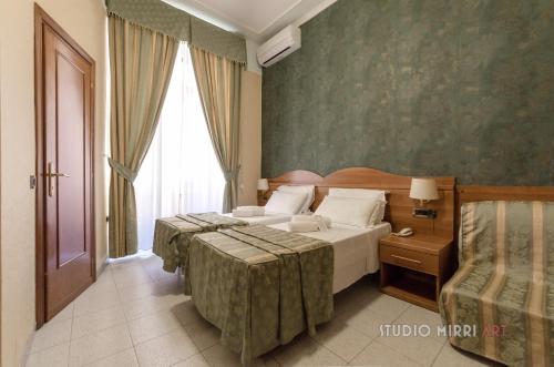 a hotel room with two beds and a window at Hotel Teti in Rome