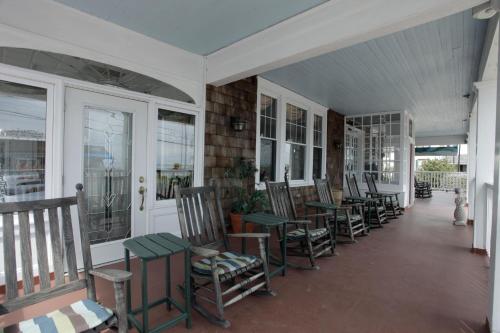 a porch with a bunch of chairs and tables at Hotel Macomber in Cape May