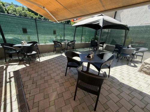 a patio with tables and chairs and an umbrella at HOTEL PERLA - Free Parking in Sarajevo