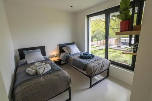 a bedroom with two beds and a window at Het Meer in Rotselaar