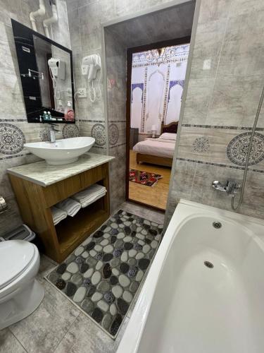 a bathroom with a tub and a sink and a toilet at Central Asia in Bukhara