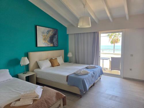 a bedroom with two beds and a view of the beach at Coco's Corfu Apartments in Ipsos