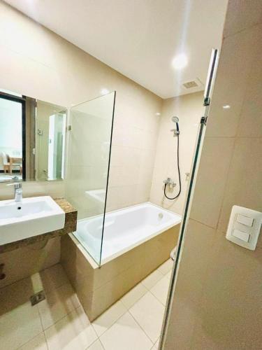 a bathroom with a shower and a tub and a sink at Mactan Newtown Condo Rental in Punta Engaño