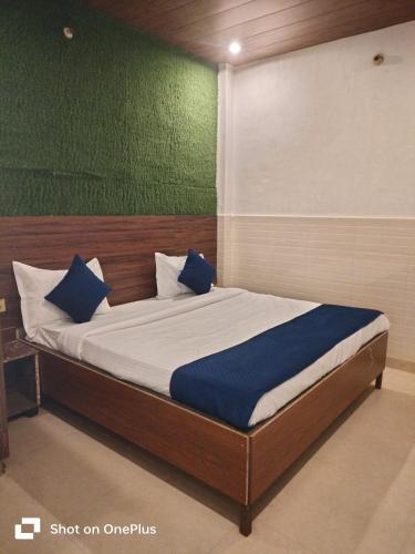 a bed with blue pillows in a room at vista home stay in Lucknow