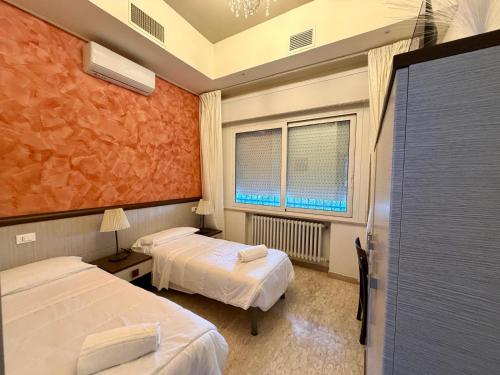 a hotel room with two beds and a window at Locanda San Biagio in Misano Adriatico
