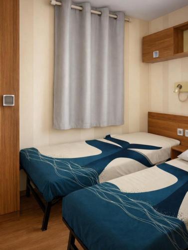 a group of three beds in a room at camping des 7 fonts in Agde