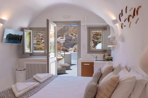 a bedroom with a bed and a view of a kitchen at EG Cave Houses in Éxo Goniá