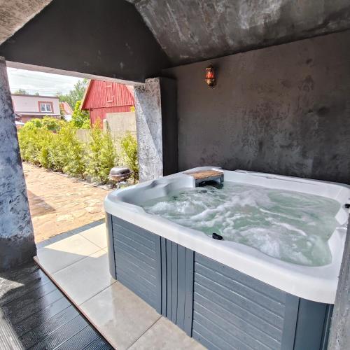 a jacuzzi tub in a backyard with a red barn at LoftLove Lubianka in Starachowice