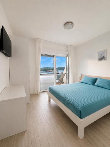 a bedroom with a bed and a view of the ocean at Aparthouse Penelope in Supetarska Draga