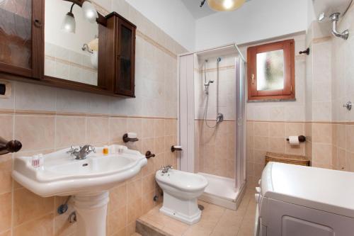 ein Bad mit einem Waschbecken, einem WC und einer Dusche in der Unterkunft La Polesana in Sorrent