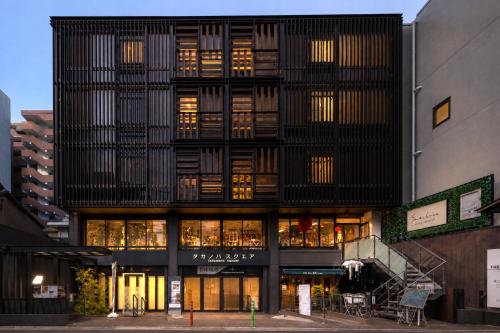 a tall black building with many windows at Shijo Guesthouse HIVE in Kyoto