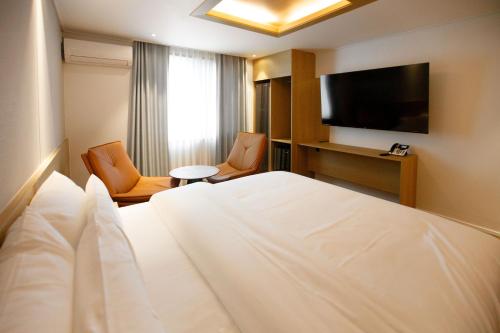a hotel room with a bed and a flat screen tv at Hotel Ieum Mokpo peace square branch in Mokpo